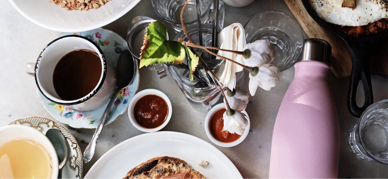 Table with food and a Swell bottle on it